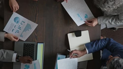 Business Meeting with Data Analysis and Handshake