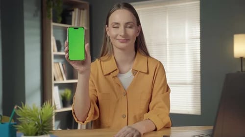 Woman Holding a Modern Smartphone with a Blank Green Screen Display Presenting New Apps or Digital