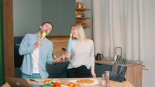 Happy Couple Dancing and Singing in Kitchen