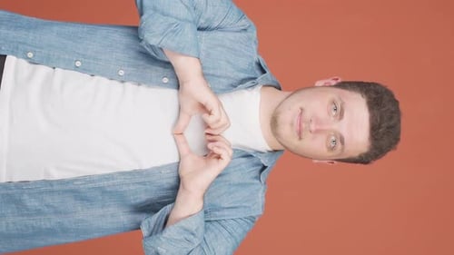 Young Adult Making Heart Shape with Hands