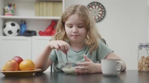 Girl Eating Cereal for Breakfast at Home