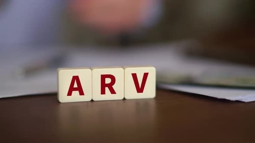 Tiles Spelling "ARV" on Desk with Money