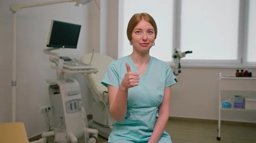 gynecologist doctor sits in gynecological office near ultrasound and gynecological chair waiting