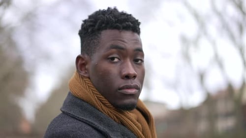 Black man looking at camera portrait tracking shot, serious emotion elegant man