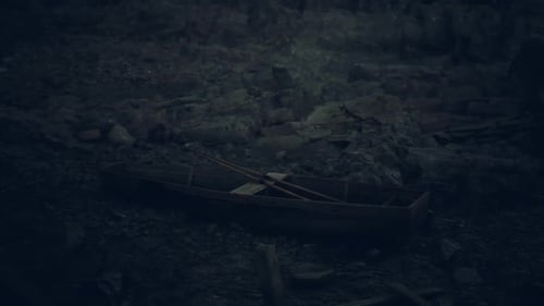 Abandoned Boat Resting on a Deserted Shore Under Dark Clouds