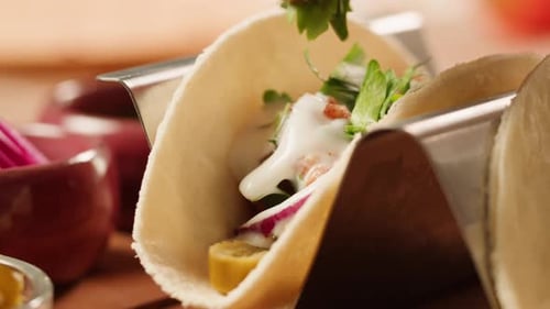 Hand Adding Greens to Delicious Taco Close Up