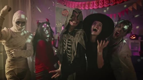 Enthusiastic friends in costumes celebrating Halloween