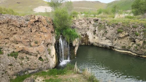 Small Waterfall Flowing into a Rock Pool