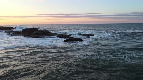 Raging Sea in the Morning at Dawn Waves Roll on the Rocky Shore Spray Soars Into the Sky