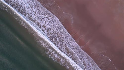 Abstract Top Down Foamy Ocean Waves Breaks Beach