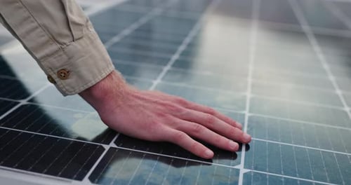 Hand touching Solar Panel for clean energy