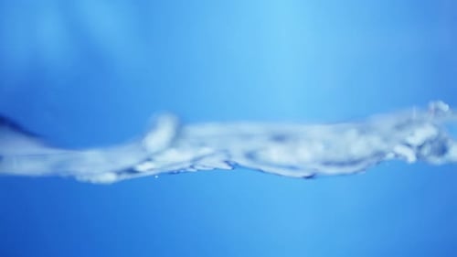 Raindrop Falling into a Pool of Water. Smooth Circular Ripples on a Calm Surface.