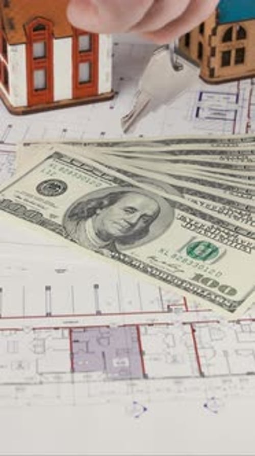 Keys on Blueprint with Hundred Dollar Bills