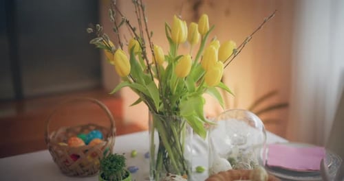 Holiday Table Decorated With Yellow Tulips and Easter Eggs
