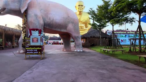 4k FPV drone flies under an Elephant statue to The biggest golden statue of a buddhist monk Luang Pu