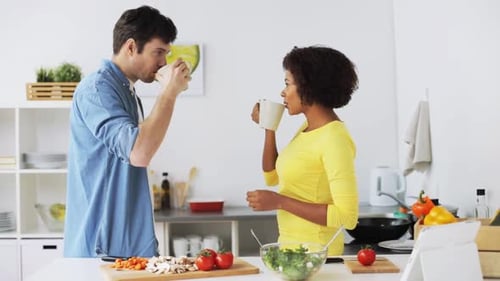 Adults Talking and Drinking Coffee in Kitchen