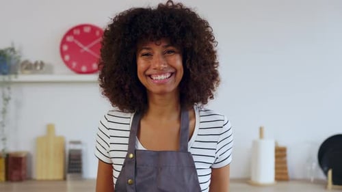 Smiling Woman Wearing Apron in Bright Kitchen