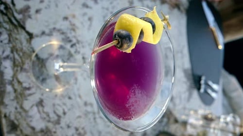 Pink red martini with blueberries on top close up