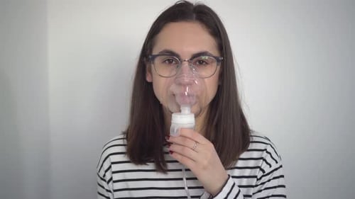 Woman Using Nebulizer Mask for Respiratory Treatment