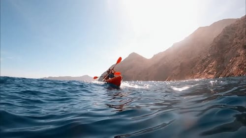Kayaker couple kayaking in beautiful crystal clear water at El Portús, Cartagena, Spain.