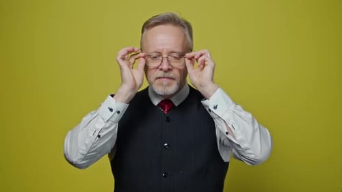 Mature Man Puts on Glasses, Expresses Confusion