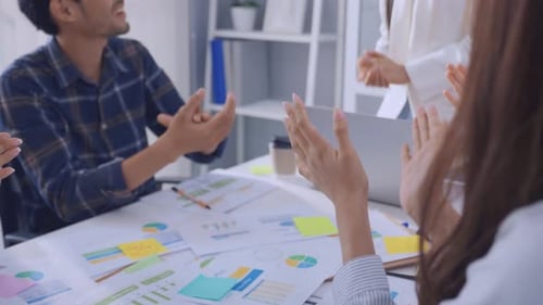 Close up hand of young businessman and businesswoman clapping together.