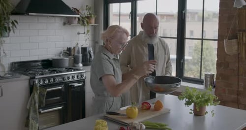 Senior Adult Couple at Home Cooking in Kitchen Together.