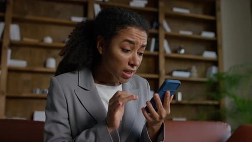 Shocked Woman Reading Bad News on Smartphone