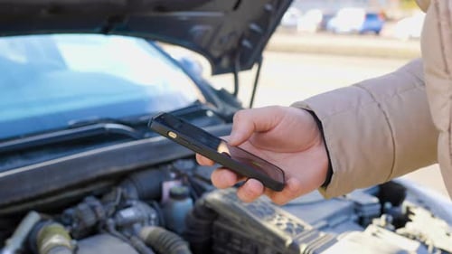 A Driver Frantically Making a Call for Assistance on His Mobile Phone