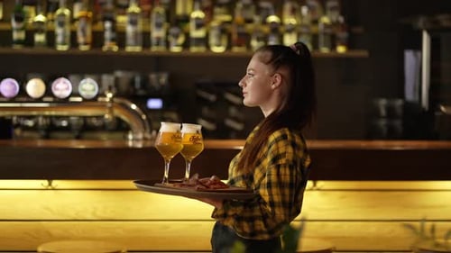 Waitress Girl Brings Beer Glasses for Men in a Pub Bar or Restaurant