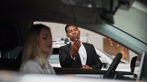 Car Salesman Explaining Vehicle to Potential Buyer