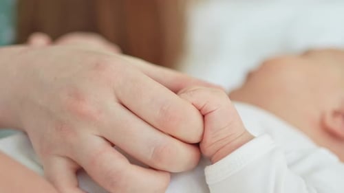 Loving Parent Gently Holds Newborn Baby's Hand