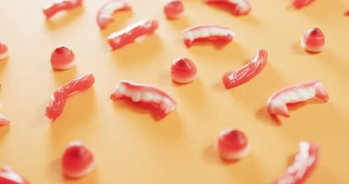 Close up of multiple halloween candies fallen against orange background