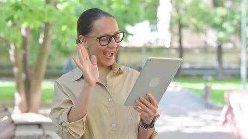 Woman Video Chatting on Tablet Outside in Park