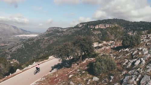 Cyclist training on bicycle in mountains.