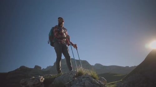 Professional mountaineers working together, climbing steep rocky terrain with trekking poles, displa