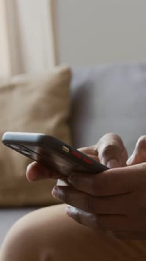 Vertical of Hands of Black Man Typing Messages on Smartphone
