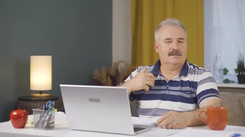 Home office worker sprays perfume on old man.