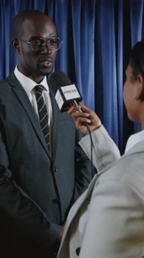 Man in Suit Answers Questions at Press Interview