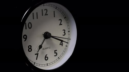The alarm clock on a black background, in the style of time-lapse video.
