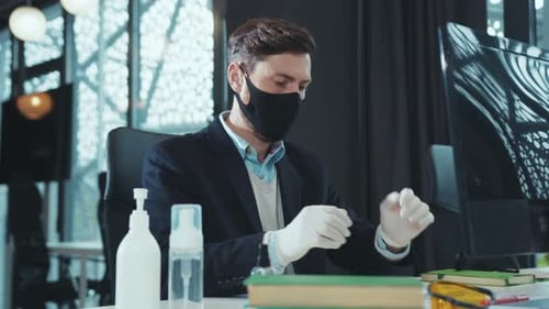 Young Adult Typing at Computer Wearing Mask and Gloves