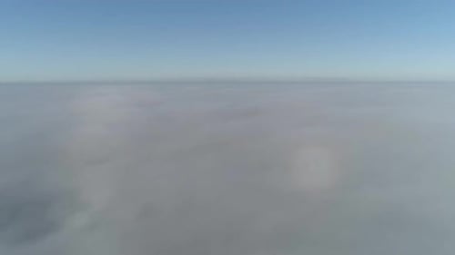 Flight over misty clouds in morning sunlight with little glory and city scape under clouds