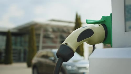 Kabel vom EV-Autoladegerät oder der Elektrofahrzeugstation per Hand einziehen