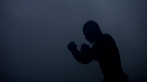 Boxer Silhouette at Dark Studio. Silhouette of Boxer Training in Dark. Mma