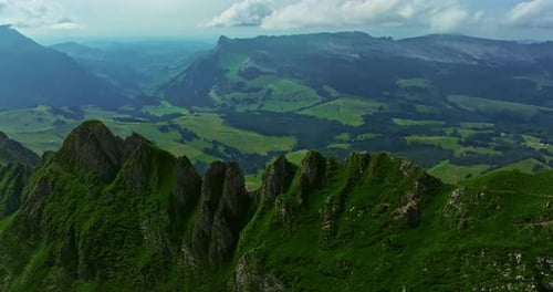 Drone Flies Over Green Picturesque Valley with Mountains in the Background High Mountains Famous