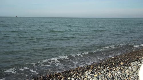 The sea surf washes the pebble beach, cinematic, calm weather at sea, a seascape for relaxation