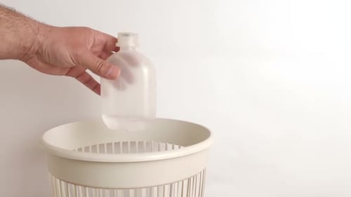 Plastic Bottle Thrown into Trash Can for Recycling