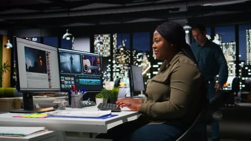 Woman Editing Video on Computer in Office at Night