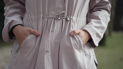 Woman with hands in coat pocket inside jacket closeup hand