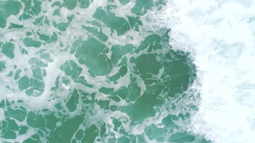 Top Down Aerial View of Giant Ocean Waves Crashing and Foaming Slow Motion Shot